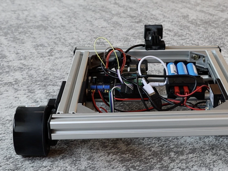 A SCUTTLE robot on a carpeted floor.